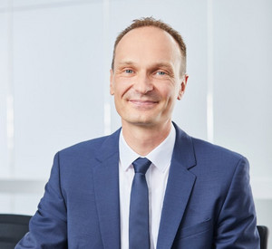 Porträtaufnahme eines Mannes in Anzug und Krawatte.